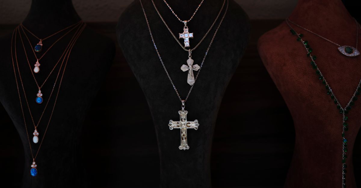 Showcase of elegant cross necklaces on velvet display busts. Perfect for religious and jewelry themes.